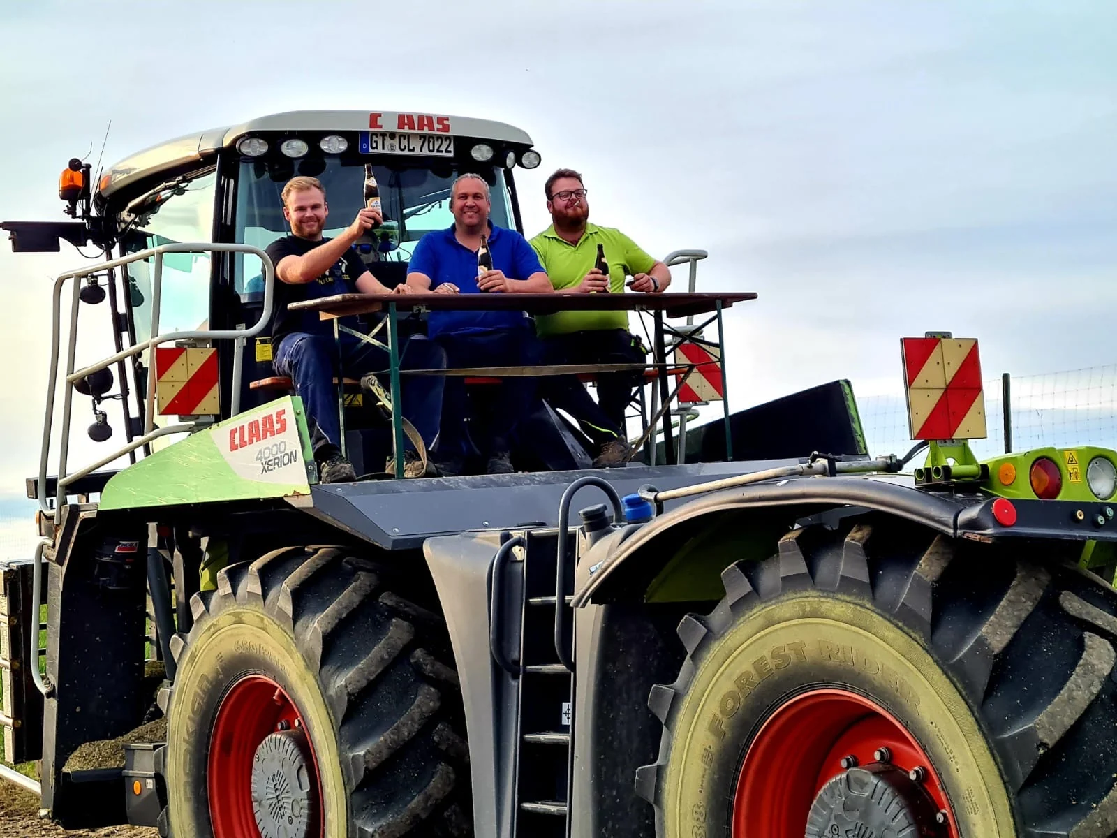 Drei Teammitglieder von Hof Jehle auf einem Traktor