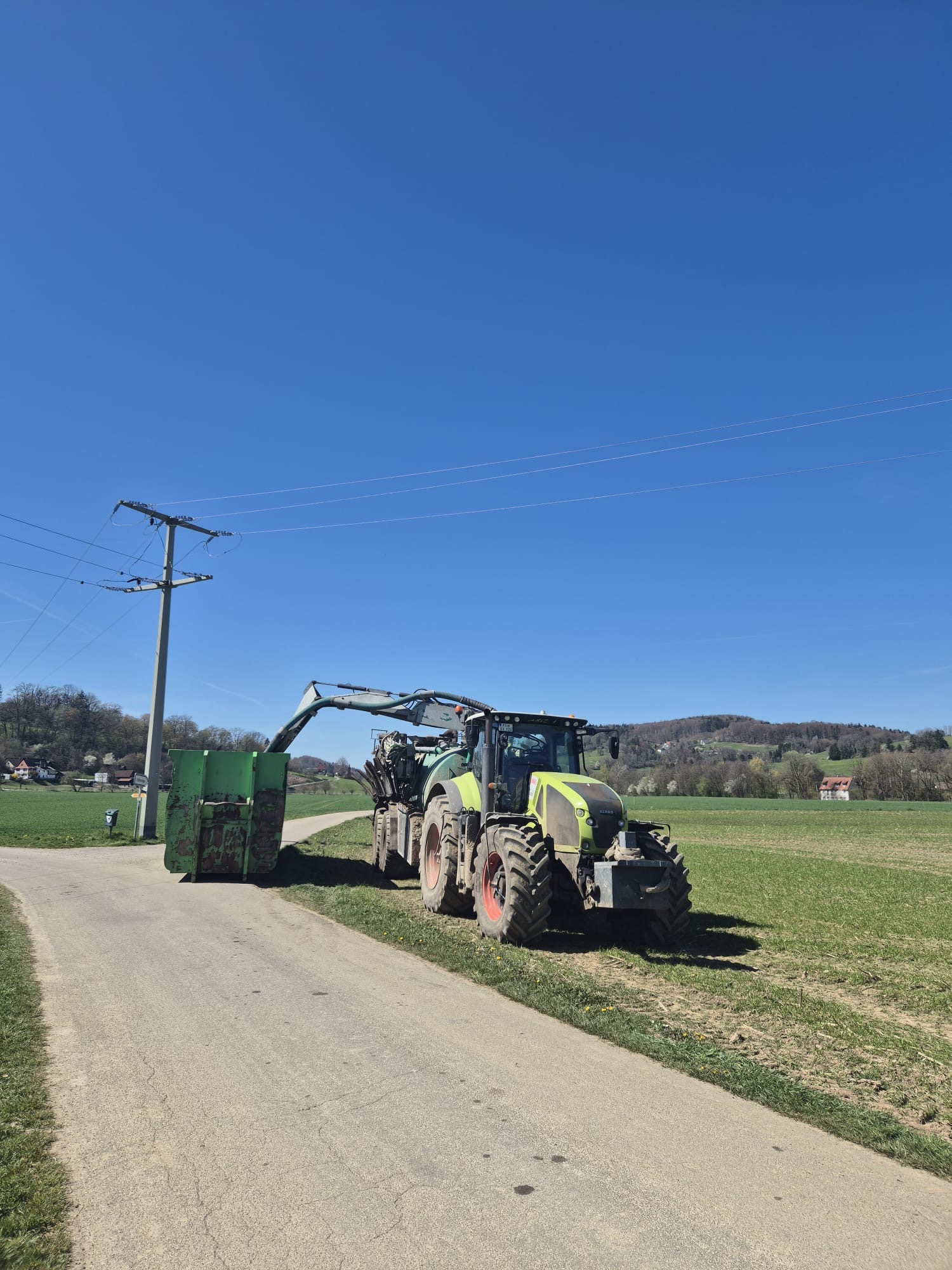 Bodennahe Gülleausbringung mit Claas Axion, Güllefass und Verteiler am Feldrand